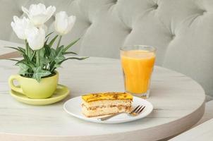 Kuchen in einem Teller und ein Glas Saft auf einem Tisch foto