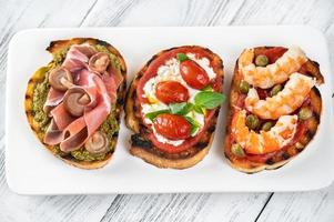 Italienische Buschettas mit verschiedenen Toppings foto