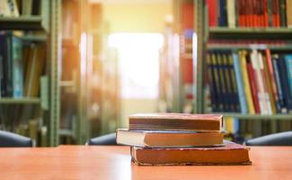 Alte Bücher auf einem Holztisch - Bücherstapel im Bibliotheksraum für Geschäfts- und Bildungshintergrund, zurück zum Schulkonzept foto