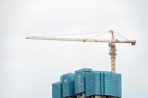 An bewölkten Tagen Höhenboom auf Hochhäusern in modernen Städten im Bau foto