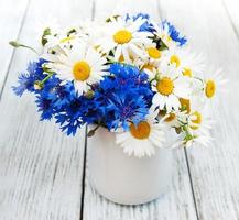 Gänseblümchen und Kornblumen in Vase foto