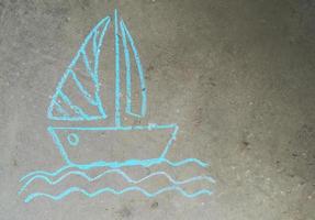 Boot mit Segel auf den Wellen wird mit Kreide auf den Asphalt gezeichnet. Kinderkreativität, Sommer, Meer, Reisen. banner mit platz für text, kopierraum foto