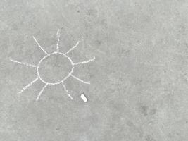 Sonne - weiße Kreidehandzeichnung auf schwarzem Asphalt foto