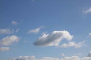 sommer blauer himmel wolkensteigung hellweißer hintergrund. schönheit klar bewölkt in sonnenschein ruhig hell winterluft hintergrund. düstere lebendige cyanfarbene landschaft in der umgebung tag horizont skyline blick frühlingswind foto