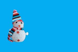 Schneemann mit gestreiftem Hut und Schal isoliert auf blauem Hintergrund. weihnachtsdekoration banner horizontal, platz für text. Neujahr foto