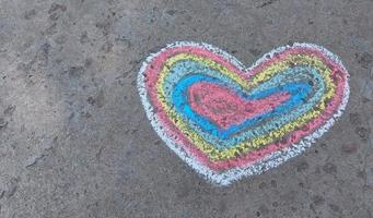 Regenbogenherz mit Kreide auf den Asphalt gezeichnet. Liebeserklärung. bannerplatz für text, valentinstag, kinderkreativitätskopierraum, sommer foto