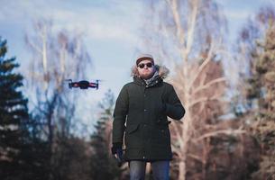 Hipster-Mann mit fliegender Drohne im Park foto