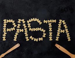 Wort Pasta auf dunklem Hintergrund foto
