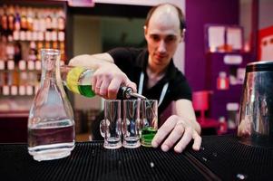 Barmann bereitet grünes mexikanisches Cocktailgetränk an der Bar zu foto
