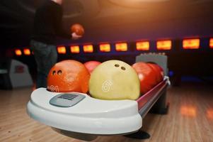 bowlingkugeln am schüssellift mit ultraviolettem hintergrundspieler foto