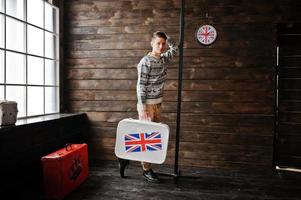 junger modemann mit dem koffer mit der britischen flagge foto