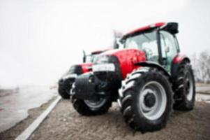 zwei neue rote traktoren bleiben bei schneewetter, verwischter effekt foto