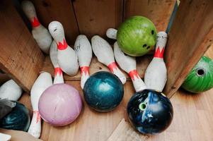 stürzte und beschädigte Bowlingkugeln mit Stiften an der Box foto