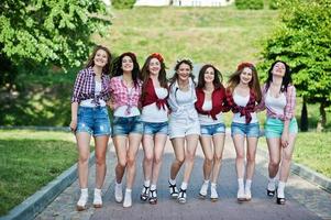 sieben fröhliche und sexy mädchen in kurzen shorts posierten und hatten spaß auf der straße im park auf einer junggesellenparty foto