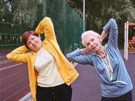 zwei reife frauen, die im park sportübungen machen. gesundes lebensstilkonzept foto