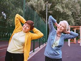 zwei reife frauen, die im park sportübungen machen. gesundes lebensstilkonzept foto