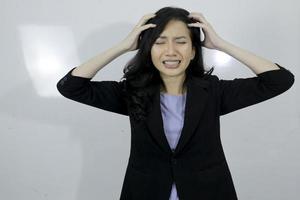 Junges asiatisches Mädchen des Geschäfts ist Stress und verwirrt über ihre Arbeit, die auf weißem Hintergrund lokalisiert wird foto