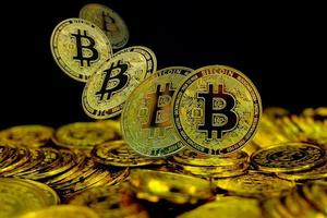 goldene Bitcoin-Kryptowährung auf Stapelgoldmünze auf schwarzem Hintergrund foto