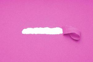 Loch in rosa Papier gerissen, um versteckten Kopierraum freizulegen foto