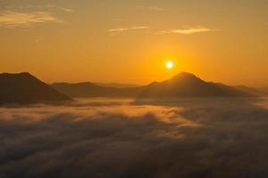 meernebel und goldener sonnenaufgang bedecken das gebiet auf dem hügel doi phu thok, chiang khan, loei, thailand mit hintergrund des sonnenaufgangs im winter. foto