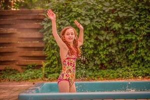 Teenager-Mädchen in einem Badeanzug im Pool. positive Stimmung des Kindes im Urlaub an einem sonnigen Tag. foto
