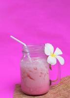 Cooles rosa Eismilchgetränk für Sommergetränke auf weißen Hintergründen vertikale Seitenansichten foto