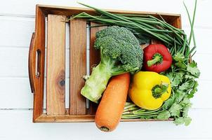 gemischtes Gemüse mit Brokkoli und Chili und Zwiebeln und Karotten auf Holzkorb oben foto