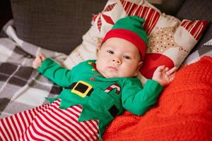 Weihnachtskonzept kleiner Junge fröhliche Elfe, die nach oben schaut, liegt auf mehrfarbig foto