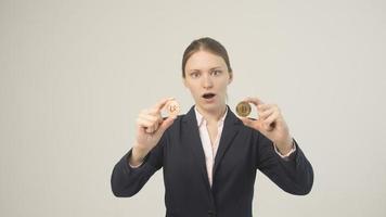 Frau, die eine physische Bitcoin-Kryptowährung in der Hand hält foto