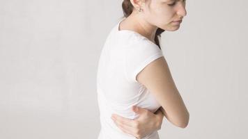 attraktive Teenagerin leidet unter Rückenschmerzen. alles auf weißem Hintergrund foto