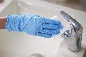 Hände in Handschuhe, Wasserhahn und Waschbecken reinigen, foto