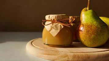 Köstliche Birnenmarmelade und frisches Obst auf Holzschneidebrett. hausgemachte Marmelade foto