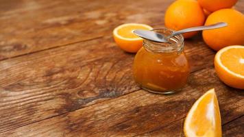 Glas Orangenmarmelade auf Holzhintergrund von oben. Platz für Texte. foto