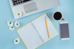 auf dem blauen hintergrund notebook bleistift, lineal und weiße blumen foto