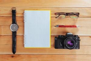 Uhr, Kamera und Notebook auf braunem Hintergrund foto