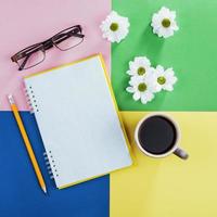 notizbuch, bleistift, brille, kaffee und duftende weiße blumen. foto