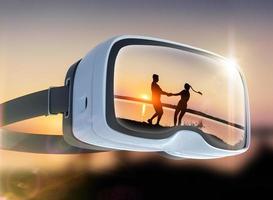 Virtual-Reality-Headset, Doppelbelichtung, romantisches Paar am Strand bei farbenfrohem Sonnenuntergang foto