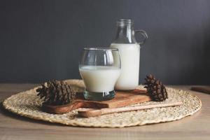 Flasche und Glas Milch auf Holzbrett foto