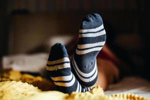 gemütliche Fußstellung in warmen Socken auf dem Bett foto