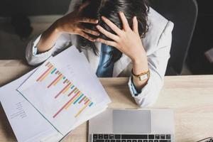 stressige arbeitnehmerin bei der arbeit mit unordentlichem schreibtisch. müde Geschäftsfrau, die sich gestresst fühlt, Überarbeitung, Bürosyndrom, Geschäftsproblem foto