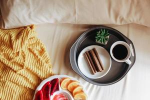 diverses Obst mit Snack und eine Tasse Kaffee zum Frühstück auf dem Bett foto