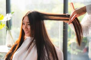 friseur und schöne kundenfrau, die behandlungshaargesundheitspflege im modestilsalon macht foto