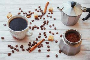 Kaffeebohnen und eine Tasse Kaffee auf dem Tisch im Hintergrund foto