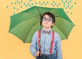 Kind mit grünem Regenschirm foto