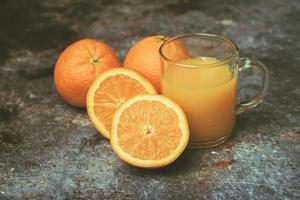 Glas Orangensaft mit frischer Orange foto