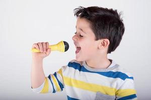 Junge singt mit einem Mikrofon foto