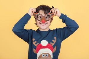 Frohe Weihnachten. Lustiges Kind in einem Rudolph-Rentier-Weihnachtskostüm foto