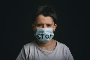 Stopp, weinendes Kind mit medizinischer Maske für Coronavirus foto