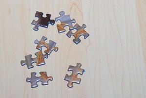 Viele Puzzleteile liegen auf Holzgrund und sind bereit zum Bauen und Spielen foto