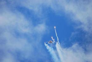 Flugzeug fliegt kopfüber und Jäger machen mit Raketenablenkung foto